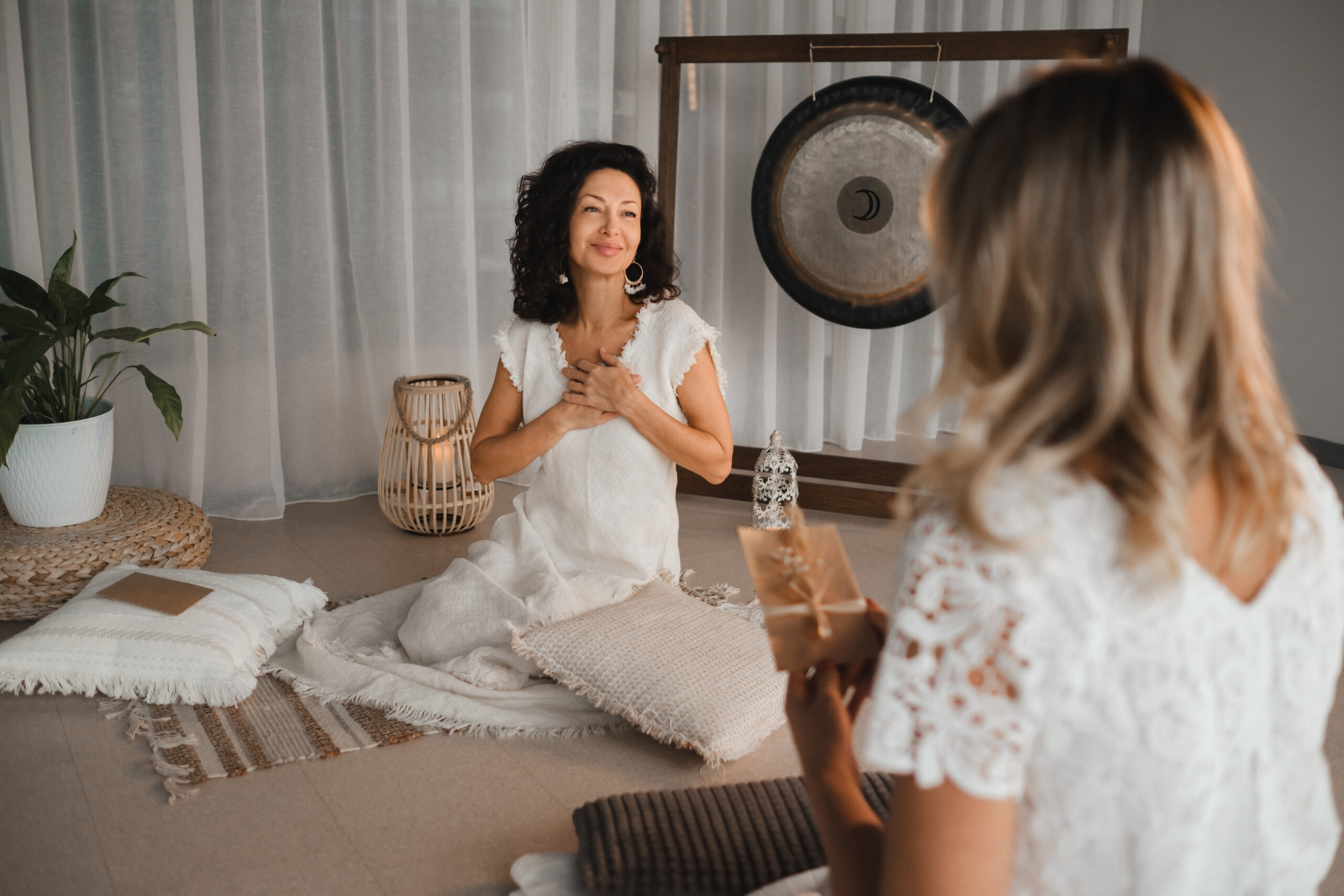 A woman in white clothes passes an envelope with a wish to another woman. The concept of the women's circle